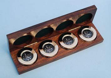Four Small Paperweight Compasses in Hardwood Case